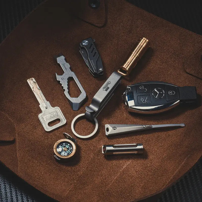 KeyUnity KM00 титаниев EDC ключодържател, показан в EDC комплект с ключове, фенерче, мултитул и автомобилен ключ