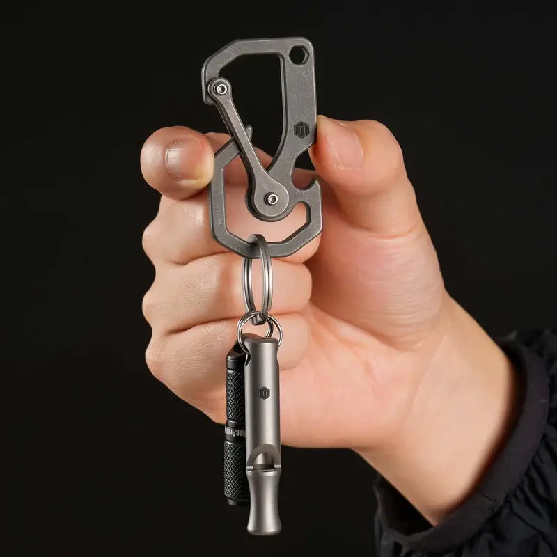 KeyUnity KU06 титаниев EDC карабинер, държан в ръка с закачен фенер, показващ реален размер и удобство при ежедневно носене